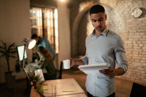 Young black businessman reading reports while working late in the office.