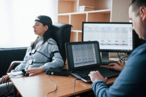 Female young theft. Girl passes lie detector in the office. Asking questions. Polygraph test